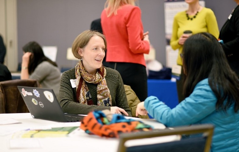 volunteer talking to teen at partnership forum