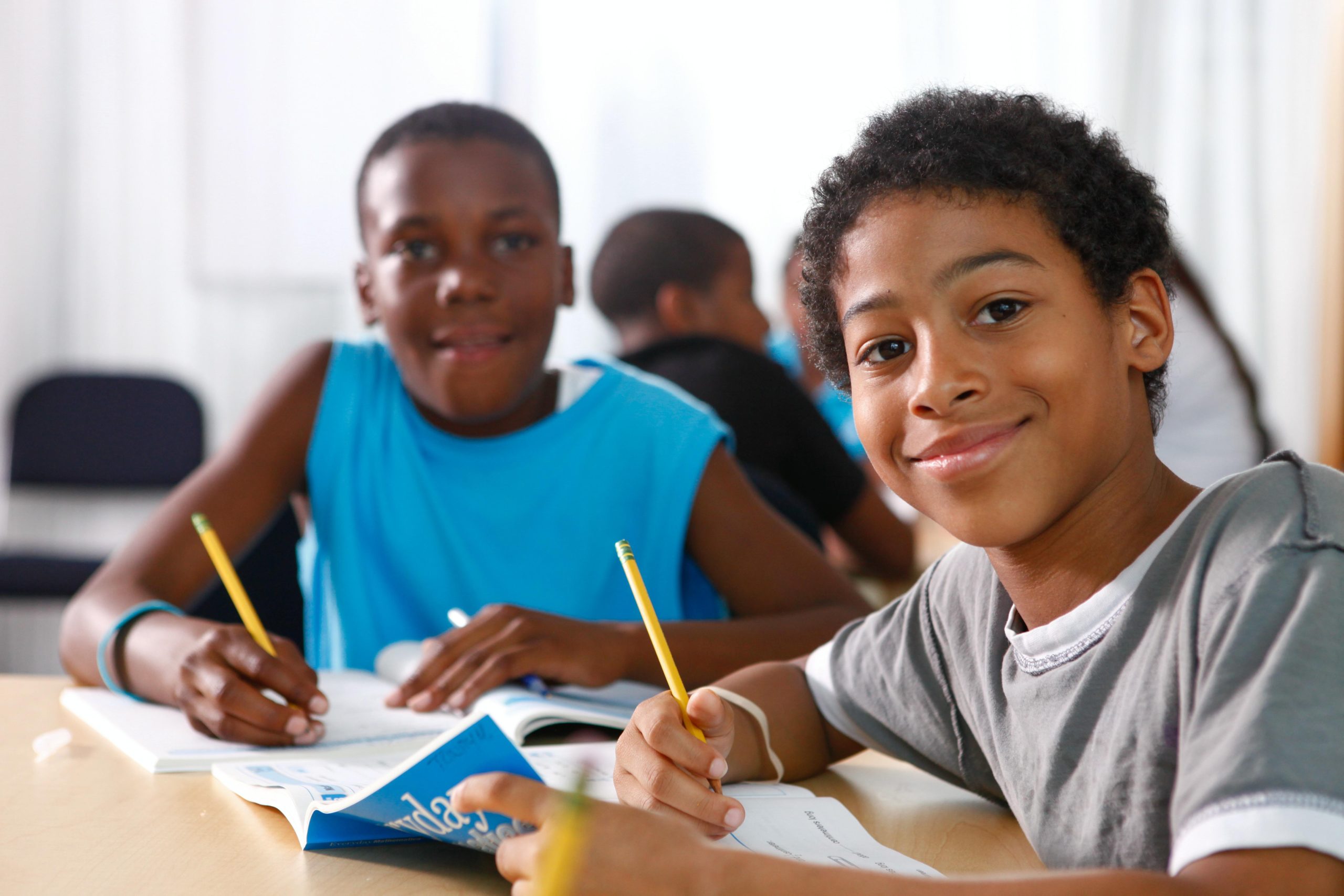 Two students smiling from their workspace